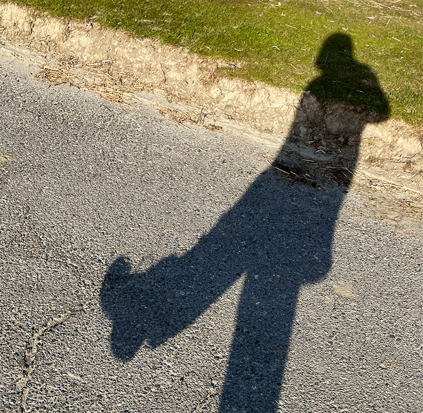 Der Schatten einer Frau, die einen großen Schritt vorwärts macht.